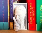 Close-up of Baba Yaga’s face and raised pistol on shelf insert