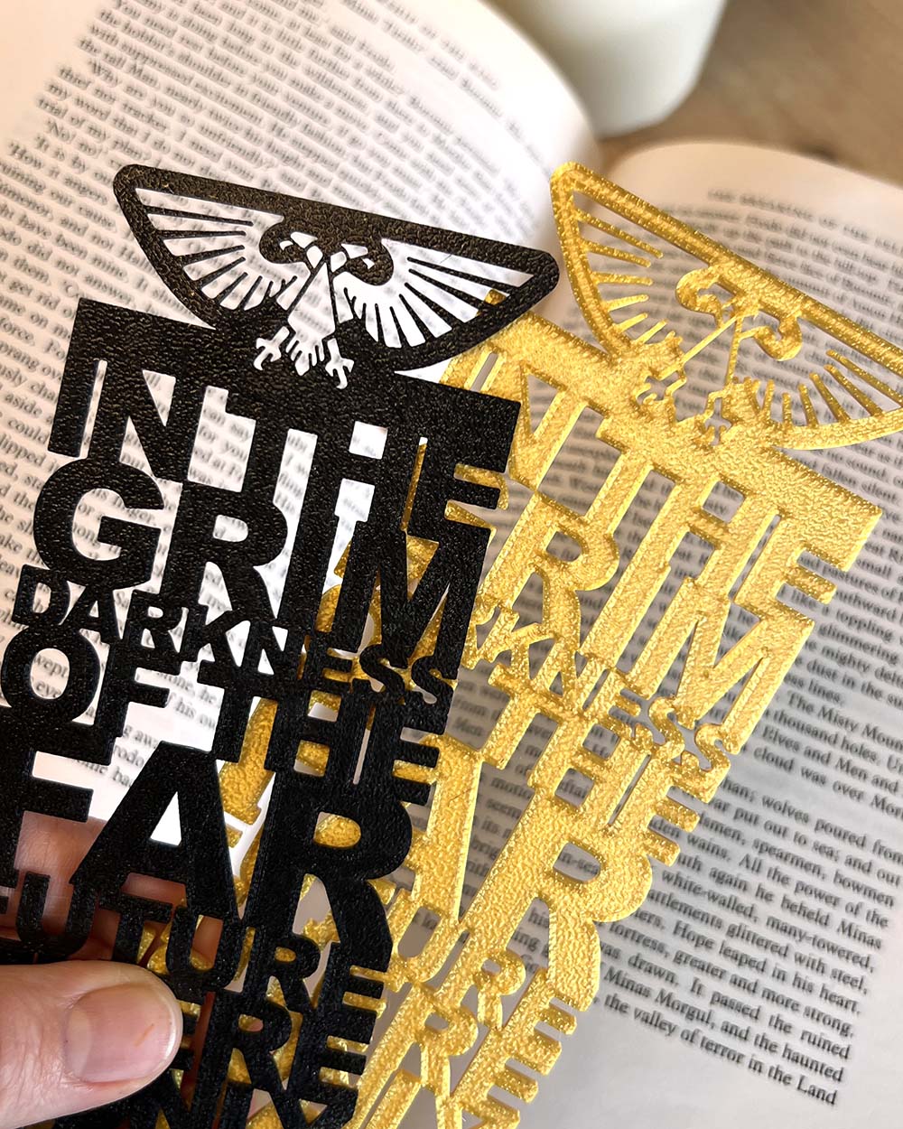 Close-up of raised imperial emblem on Warhammer 40K bookmark in gold and black