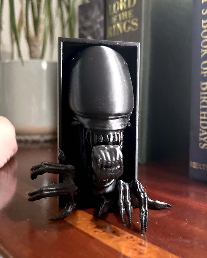 Xenomorph book nook Alien inspired shelf insert 3D printed alien monster bookshelf décor with elongated skull Sci-fi horror book nook gift featuring Xenomorph design Alien-inspired book nook insert with sharp teeth and detail Creepy space horror shelf décor Xenomorph figure